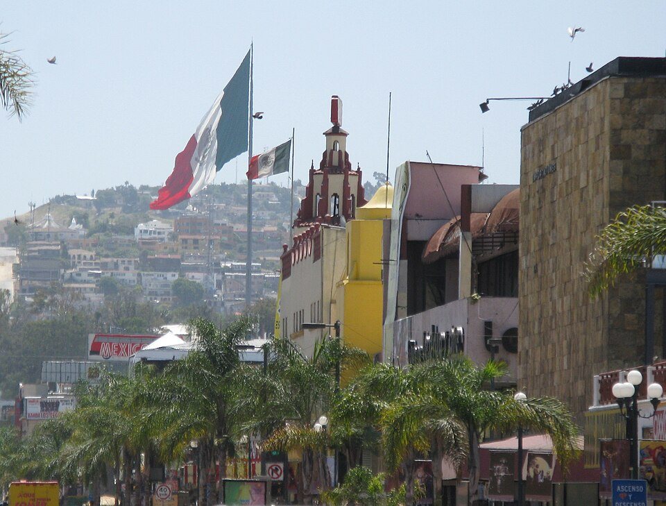 Avenida Revolución de Tijuana con la Bandera Monumental al fondo y las palmeras del centro histórico